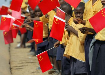 Liberian children hold Chinese flags before the arrival of China's President Hu Jintao in Monrovia February 1, 2007. Thousands of cheering Liberians lined the streets of the capital Monrovia on Thursday to greet Hu, hoping for desperately needed investment for their war-scarred nation. REUTERS/Christopher Herwig (LIBERIA) - RTR1LVK9