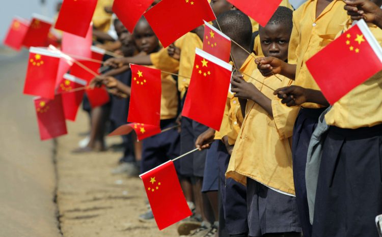 Liberian children hold Chinese flags before the arrival of China's President Hu Jintao in Monrovia February 1, 2007. Thousands of cheering Liberians lined the streets of the capital Monrovia on Thursday to greet Hu, hoping for desperately needed investment for their war-scarred nation. REUTERS/Christopher Herwig (LIBERIA) - RTR1LVK9