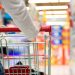 A young woman pulling a shopping cart in a mall. Extreme shallow DOF with focus on her hands."n