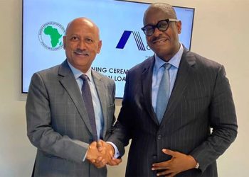 Sanjeev Gupta, membre du Conseil d'administration et directeur exécutif des services financiers d'Africa Finance Corporation, et Solomon Quaynor, vice-président du Groupe de la Banque africaine de développement, chargé du Secteur privé, de l'Infrastructure et de l'Industrialisation, se serrent la main après avoir signé une ligne de crédit à long terme de 350 millions de dollars, le 4 décembre 2023 à Dubaï.